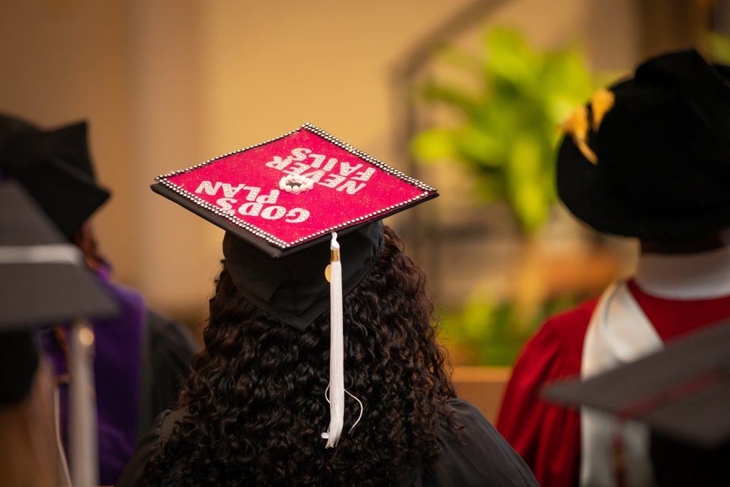 Student graduation cap reads "God's plan never fails"